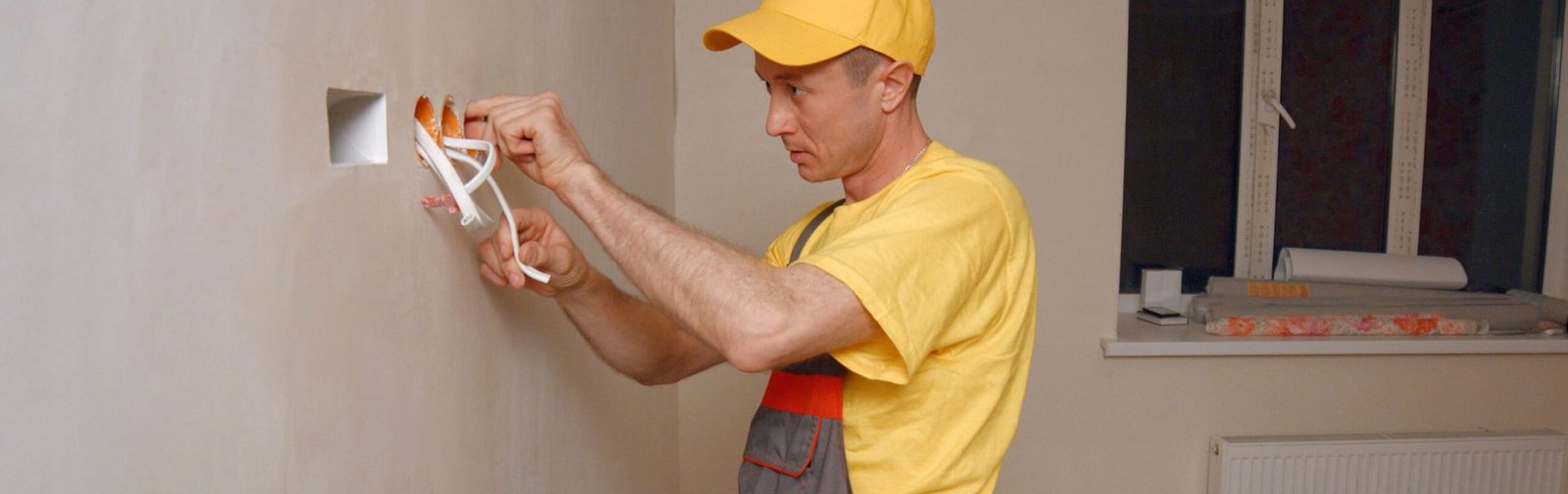 Electrician puts socket. Electrician puts socket. Electrician working with wires in new apartment.