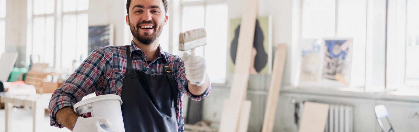 Happy young painter holding paint brush and showing it to camera Happy young painter holding paint brush and showing it to camera.